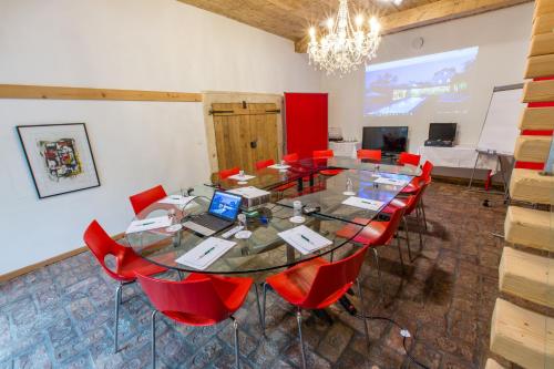 a conference room with a large table and red chairs at Hotel Landhaus Moserhof in Gumpoldskirchen