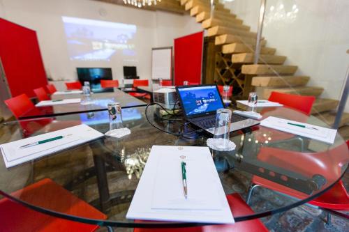 a conference room with a glass table with a laptop on it at Hotel Landhaus Moserhof in Gumpoldskirchen