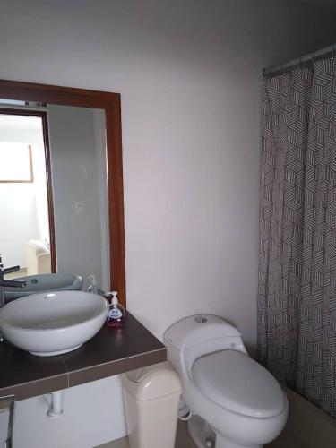 a bathroom with a white toilet and a sink at Surfers Paradise - Casa Caro in Punta Negra