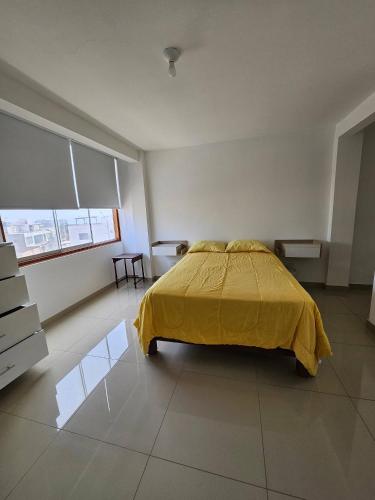 a bedroom with a bed with a yellow blanket at Surfers Paradise - Casa Caro in Punta Negra