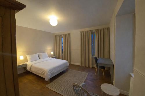a hotel room with a bed and a table and chairs at Les volets verts in Pont-Croix