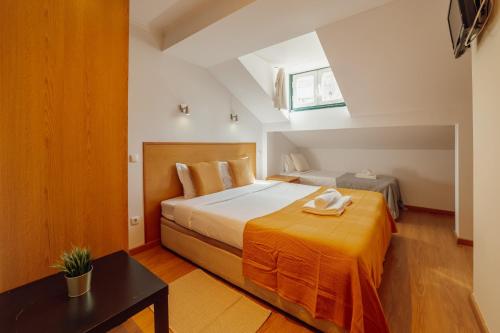 a bedroom with a large bed with an orange blanket at DownTown Guest House in Lisbon