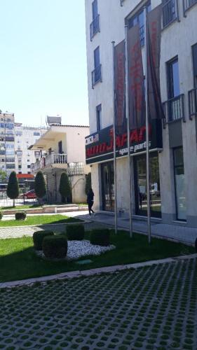 a woman walking in front of a building at Isabel Rooms in Tirana