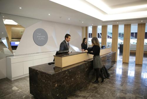 a man and two women standing at a reception desk at The Ankara Hotel in Ankara