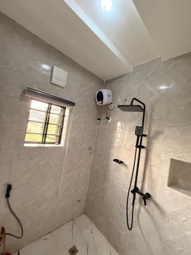 a bathroom with a shower with a shower at De Rex Luxury Apartment in Akwa