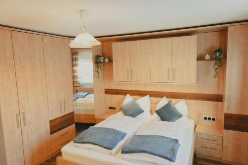 a bedroom with a white bed with wooden cabinets at Ferienhaus am Wildbachberg - Platz für die ganze Familie in Deutschlandsberg