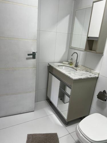 a bathroom with a sink and a toilet at Casa com churrasqueira e ar para até 8 pessoas in Guabiruba