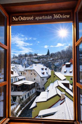 a view of a snowy city from a window at Penzion na Ostrově in Český Krumlov