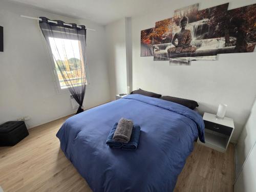 a bedroom with a blue bed and a window at T2 Confort - Clim, Piscine & Parking privé in Montauban