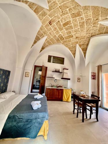 a bedroom with a bed and a table in a room at Corte della Luce in Ugento