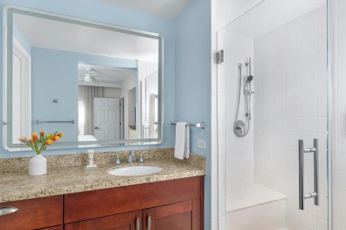 a bathroom with a sink and a shower with a mirror at Marriott's Harbour Lake in Orlando