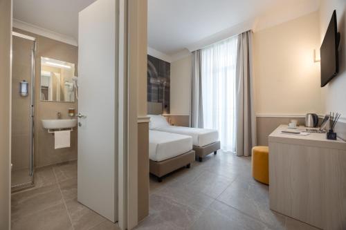 a hotel room with a bed and a bathroom at Hotel Astoria Garden in Rome