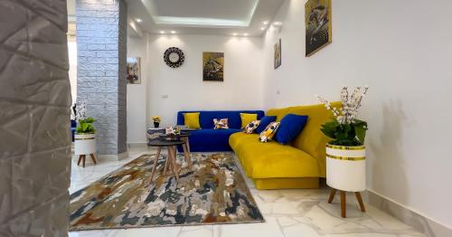 a living room with a yellow couch and a table at Casa Pyramids View in Cairo