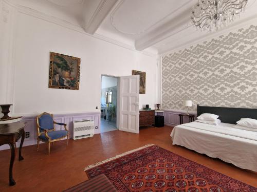 a bedroom with a bed and a desk and a chair at Palais de Luppé, Chambre d'hôtes in Arles