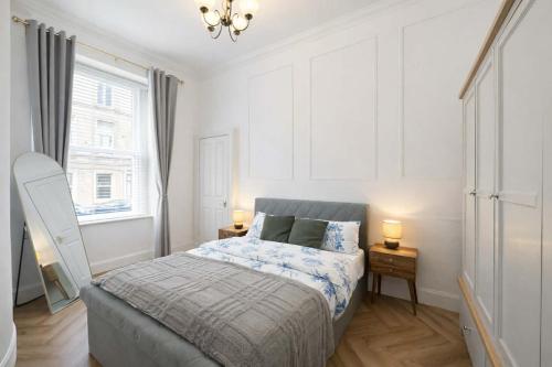 a bedroom with a bed and two lamps and a window at The Barony Fox in Edinburgh