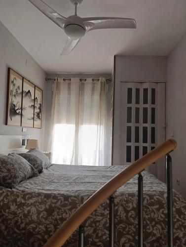 a bedroom with a bed with a ceiling fan at Loft con encanto de Raúl y Rosa in San Sebastián de los Reyes