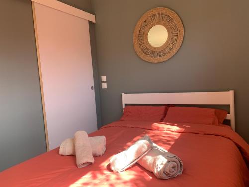 a bedroom with a bed with towels and a mirror at Tiny House le Cocon de Jardin in Saverne