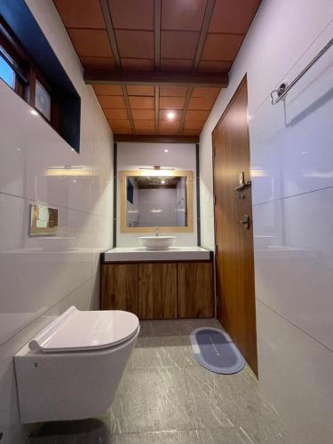 a bathroom with a toilet and a sink at Ponyo Stays in Cochin