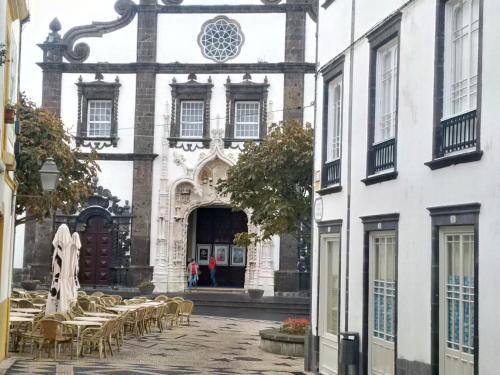 a building with tables and chairs in front of it at Watching Azores Apartment in Ponta Delgada