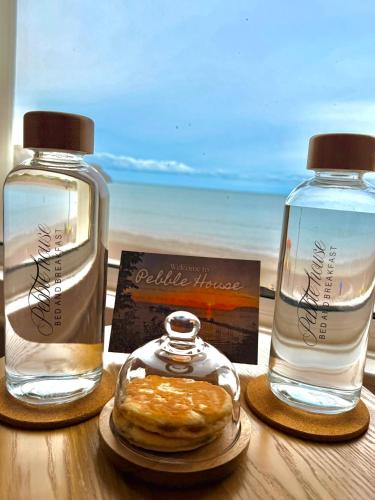 a table with two bottles of water and a donut at Pebble House in Llandudno