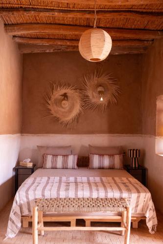 a bedroom with a bed with two pillows at Muma Lodge in Bouihat