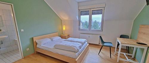 a bedroom with a bed and a desk and a table and chairs at Le Relais - Appart'Hotel in Düsseldorf