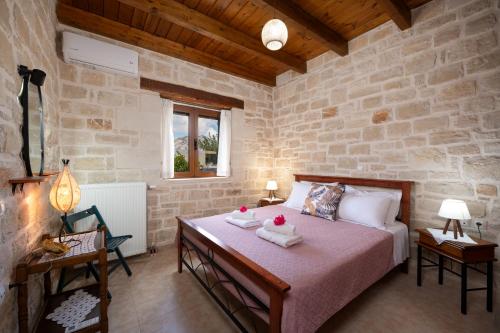 a bedroom with a bed and a stone wall at Drys Stone House in Miriokéfala