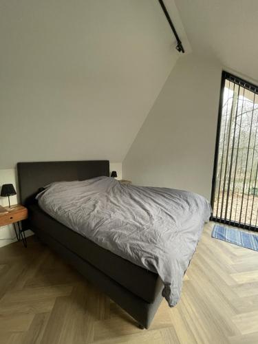 a bedroom with a bed and a window at Villa Hogerop in Bennekom