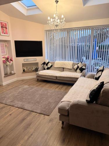 a living room with a couch and a flat screen tv at Stay solihull 5 mins to NEC and AIRPORT SLEEPS 6 contractor friendly 3 bathrooms driveway parking 3 in Solihull