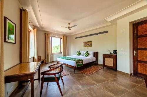 a bedroom with a bed and a table and chairs at Seraibagh Ranthmabore in Khilchipur
