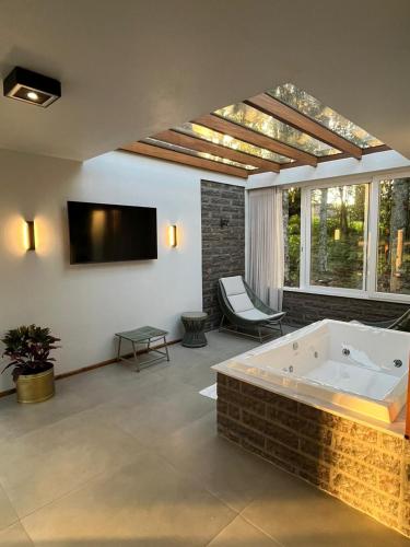 a large room with a bath tub and a tv at Refúgio das Araucárias in Nova Petrópolis