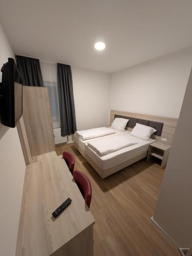 a bedroom with a bed and a desk and chairs at Hotel Shiva in Maingründel