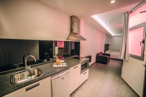 eine Küche mit einem Waschbecken und einem Sofa in einem Zimmer in der Unterkunft Mannix Urban Apartments in Las Palmas de Gran Canaria