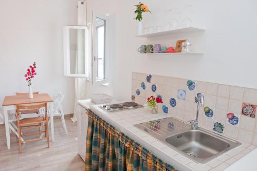 a kitchen with a sink and a table at Corte della Luce in Ugento