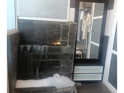 a stone shower in a bathroom with snow on the floor at Valley View at Twin Oaks in Dharampur