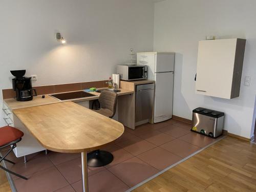 a small kitchen with a table and a refrigerator at Barrierefreie Ferienwohnung in Bad Windsheim