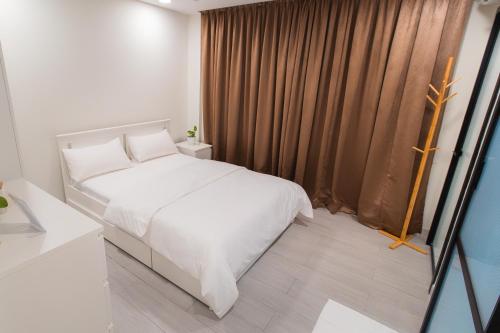 a bedroom with a white bed and a window at Sunrise Stay in Male City