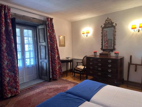 a bedroom with a bed and a dresser and a mirror at Casa de Nossa Senhora da Piedade in Ponte de Lima