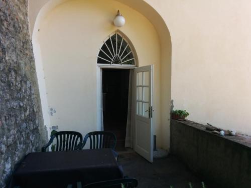 an archway leading to a door with a table and chairs at Villa Palagione Centro Interculturale in Volterra
