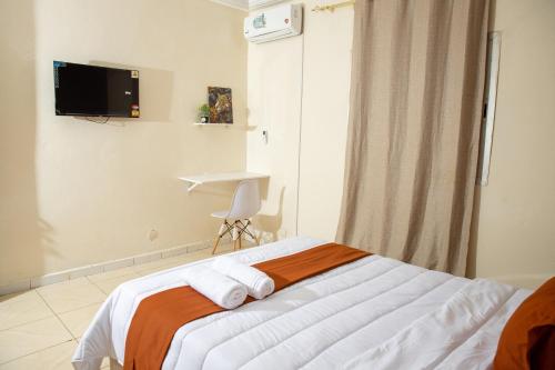 una camera da letto con un letto e una televisione a parete di Pro hébergement a Dakar