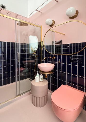 a bathroom with a pink toilet and a sink at 4th Floor Bed and Breakfast in Warsaw