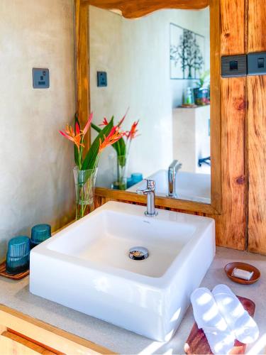 a white sink in a bathroom with a mirror at Heliconia Ledge in Mawanella