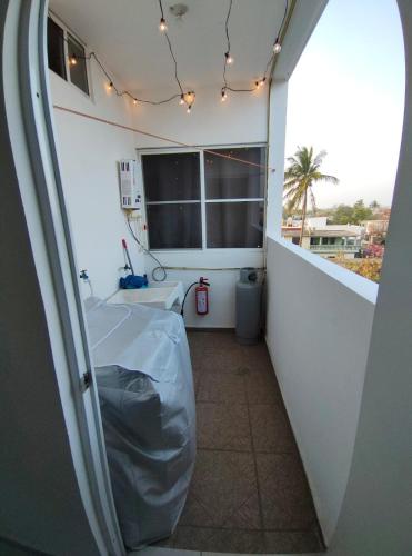 a room with a balcony with a bed and a window at Departamento a 3 min de Playa Miramar in Ciudad Madero