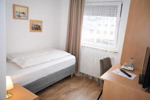 ein kleines Schlafzimmer mit einem Bett und einem Fenster in der Unterkunft Hotel Discovery in Stuttgart