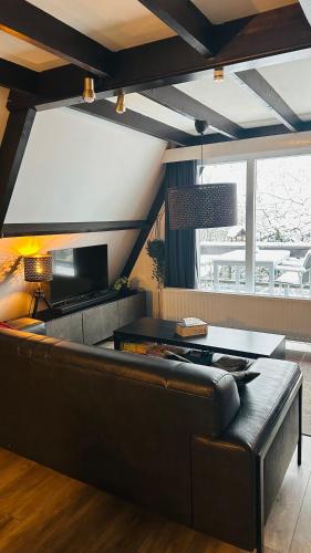 a living room with a couch and a table at Villa Edice met zwembad en restaurant in Durbuy - honden toegelaten in Durbuy