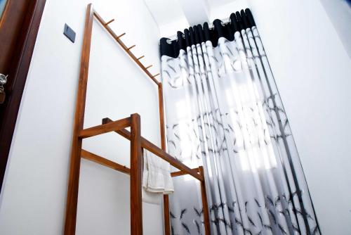 a room with white curtains and a wooden rack at Ella Chalana Dew In in Ella