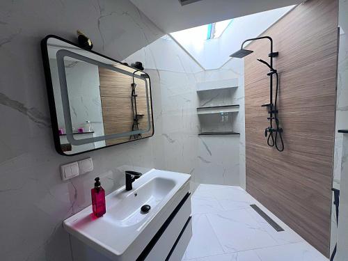 a white bathroom with a sink and a mirror at DreamCatcher Paragliders in Tamelalt