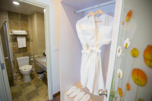 a bathroom with a toilet and a robe on a door at Hi Chiangrai Hotel-SHA Extra Plus in Chiang Rai