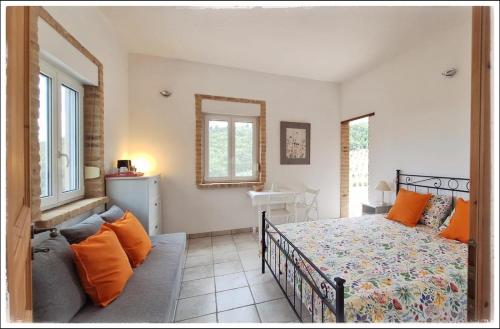 a bedroom with a bed and a couch at La Fonte e l Ulivo in Ripatransone