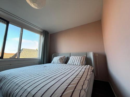 a bedroom with a bed and a large window at Lovely City Center Apartment in Alkmaar